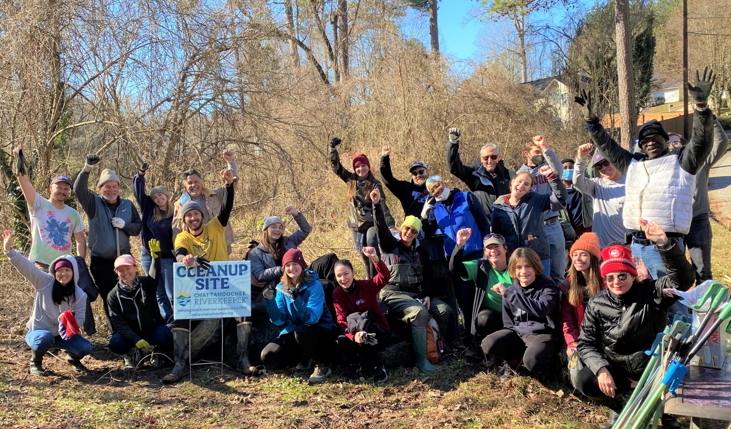 Group of volunteers posing for photo outdoors.