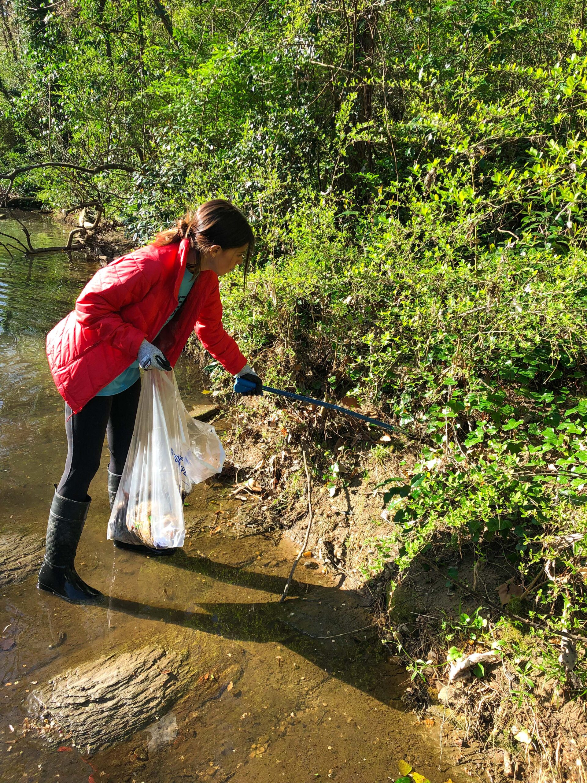 Individual cleans trash out of creek.